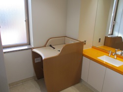 1階女性用トイレ内のおむつ替え用ベッドの写真